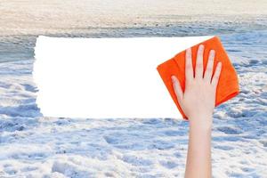 hand deletes winter snow by orange rag photo