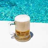 mug with cold light beer on the outdoor pool photo