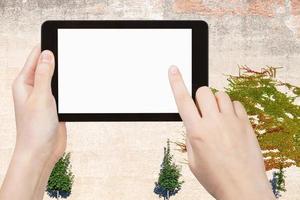 hands with tablet with cutout screen and wall photo