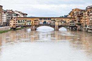muddy water of Arno and Ponte Vecchio in autumn photo