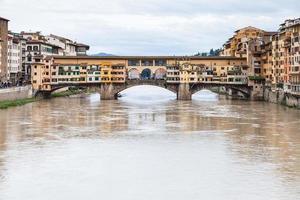 agua turbia de arno y ponte vecchio en otoño foto