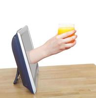 glass with fresh orange juice in hand leans out TV photo