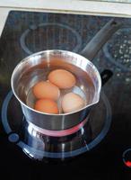 Chicken eggs are cooked in metal pot photo