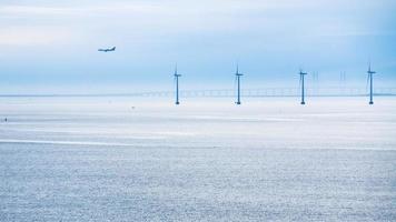 airplane, bridge and offshore wind farm in morning photo