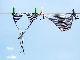 Striped swimsuit is dried on the clothesline photo