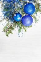 adornos navideños azules y ramitas en papel en blanco foto