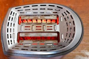 two slices of bread toasting in metal toaster photo