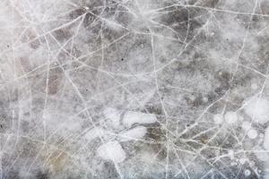 cracked ice on frozen puddle in winter photo