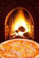 pizza con jamón y fuego abierto en horno foto