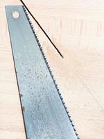 hacksaw at wooden board photo