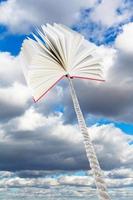 book tied on rope soars into grey clouds photo