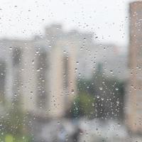 rain drops on window glass and blurred urban house photo