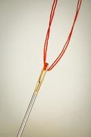 needle eye with red thread photo