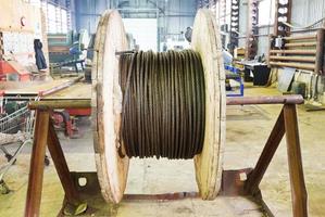 industrial wooden reel with steel rope in workshop photo