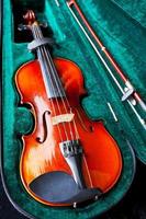 violín con arco en estuche de terciopelo verde foto