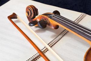 arco de violín y pergamino en el libro de música foto