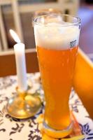 vaso de cerveza alemana y vela encendida foto