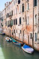 boats near shabby urban house in Venice city photo