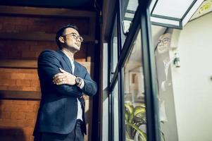 A mature business manager smiling confidently looks at the camera standing in the office at a team meeting photo