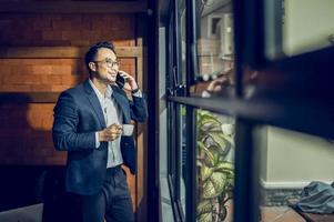 A mature business manager smiling confidently looks at the camera standing in the office at a team meeting photo