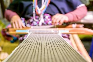 Closeup and crop fabric on blurred Thailander Hill tribe old ladies are weaving photo