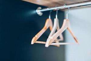 Empty Wooden hangers on rail in closet photo