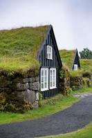 típica casa rural islandesa cubierta de maleza en el día nublado foto