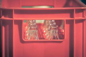 Red Plastic Crate with Empty Glass Bottles photo