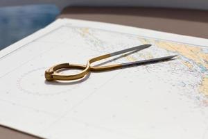 Pair of compasses for navigation on a sea map photo
