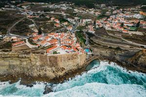 vista aérea por drones de azenhas do mar, un pequeño pueblo portugués situado al borde de un acantilado en una ubicación impresionante en la costa cerca de sintra foto