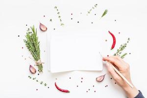 Blank notepad pages with greens herbs and spices photo