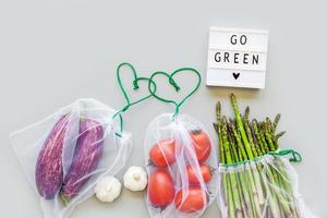 Fresh vegetables in reusable produce shopping bags photo