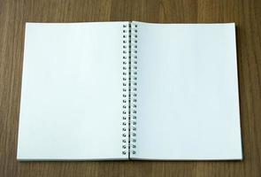 open spiral notebook on dark wood background photo