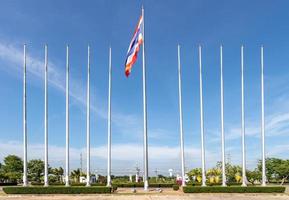 bandera tailandesa en los postes con cielo azul nube y árbol en la parte trasera. foto