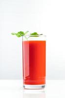 Jugo de tomate dietético con perejil sobre fondo blanco. batido vegetal vegano. foto