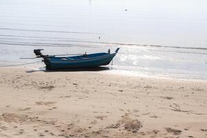 Small fishing boats aground on the beach with trees in the background. photo