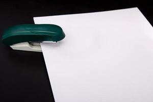 stapler and a sheet of paper photo