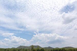 Blue sky with trees, clouds and mountains, sky background image photo