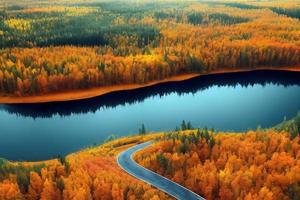 vista de drones de camino rural en bosque de otoño amarillo y naranja con lago azul en finlandia foto