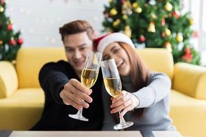 hermosa pareja enamorada levantando copas de champán para la celebración de navidad y año nuevo foto