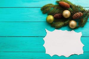 Frame of pine cones on a Christmas tree on blue wooden background. Top view photo