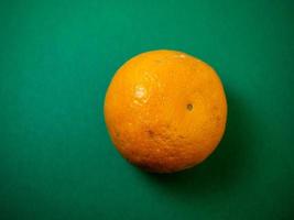 Tangerines on a green background. Whole juicy fruits. photo