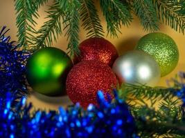 New Year's card, decorations. Balls, tinsel and fir branches on a beige background. photo