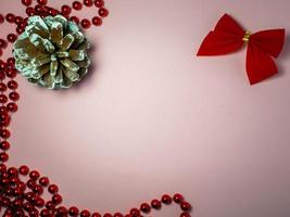 New Year card. Red bow, red beads and a fir cone. photo