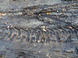 Heavy machinery wheel marks on wet ground. Tractor tire track photo