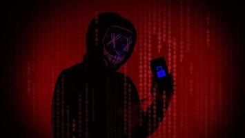 Digital security Concept. Anonymous hacker with mask holding smartphone hacked. photo