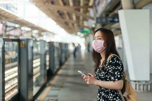 Young asian woman passenger waiting subway train with City on day background with copy space.