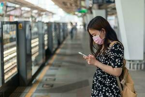 Young asian woman passenger waiting subway train when traveling in big city