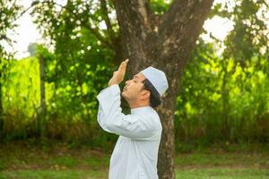 Asian muslim man praying to god photo