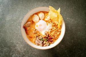 instant noodles with pork and meatballs in spicy soup photo